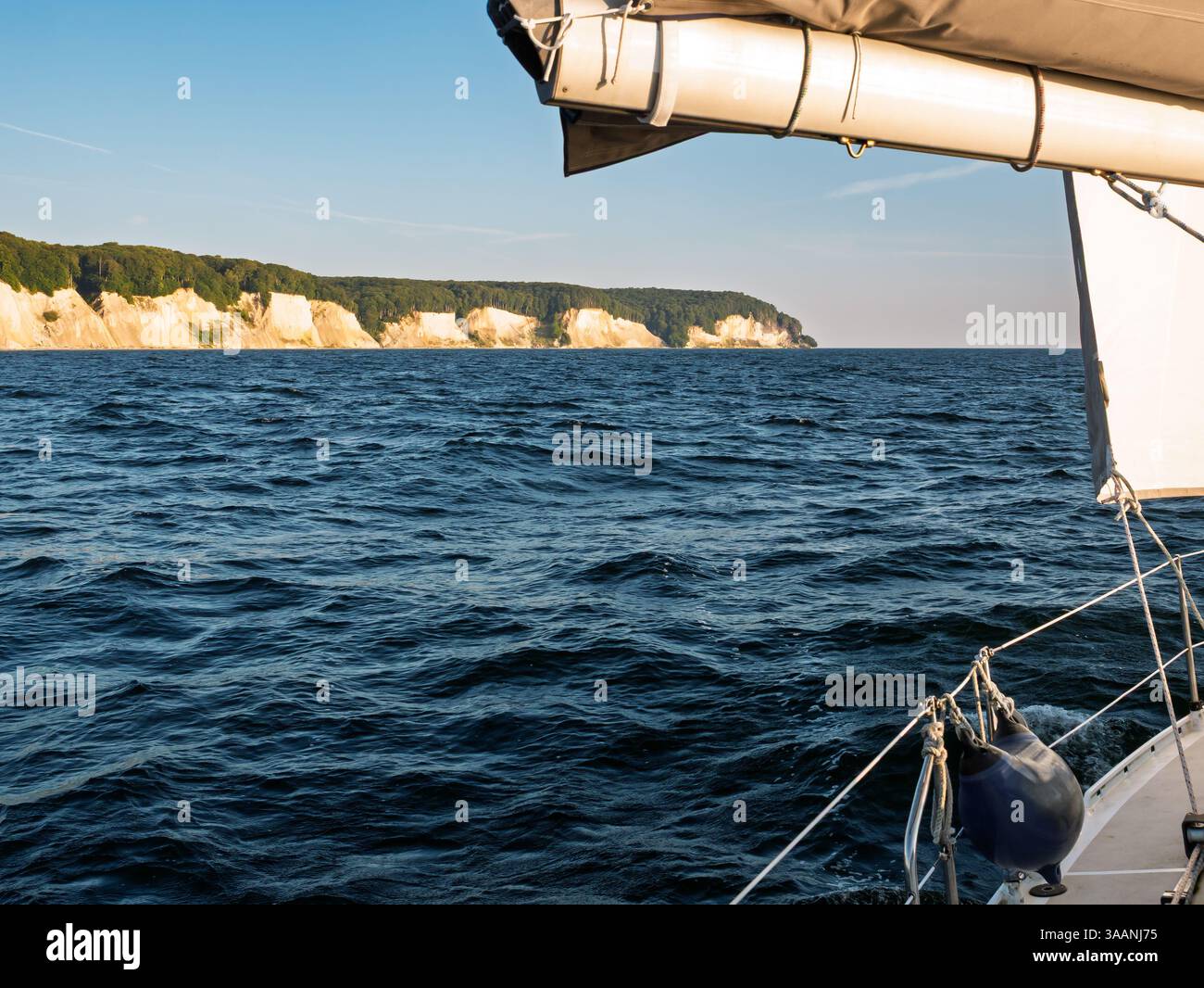 Barca a vela sul Mar Baltico con vista delle scogliere di gesso lungo la costa del Parco Nazionale di Jasmund, Rügen, Meclemburgo-Vorpommern, Germania, la mattina presto Foto Stock