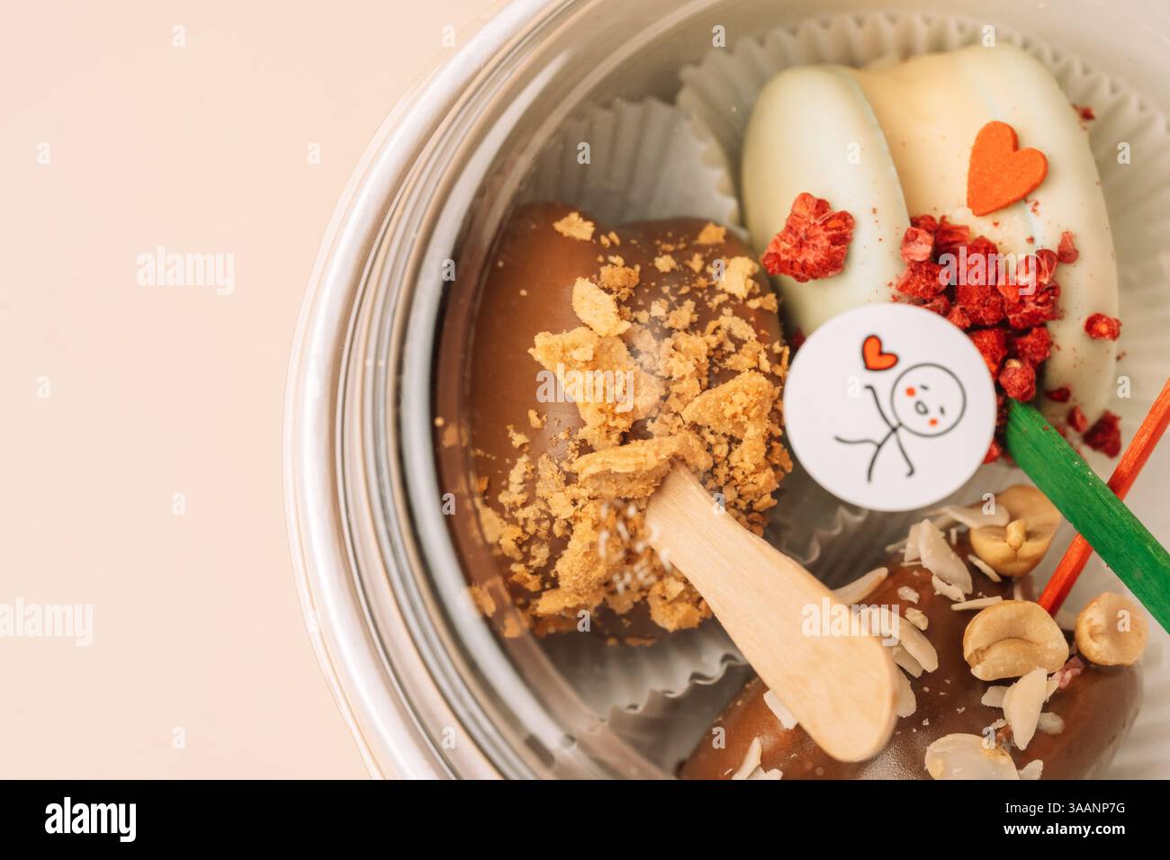 Dessert francesi al cioccolato. Macaron per torte in un contenitore, colori pastello, macaroon decorato con noci e cuori diversi. Foto Stock