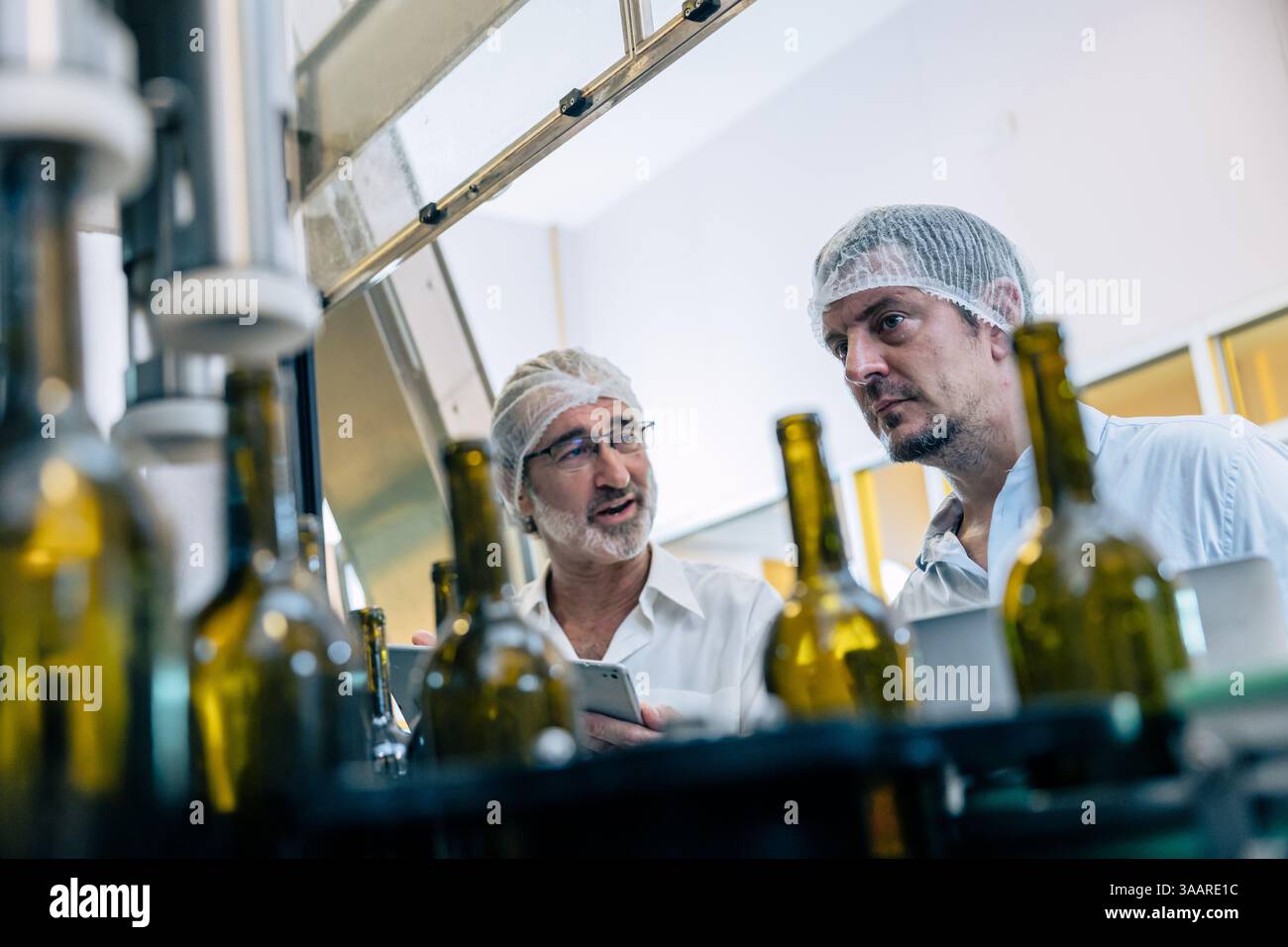 team di tecnici professionisti tecnici tecnici tecnici manutenzione di esperti. uomo che controlla la macchina nella linea di produzione della fabbrica di bevande per certificare lo standard di qualità Foto Stock