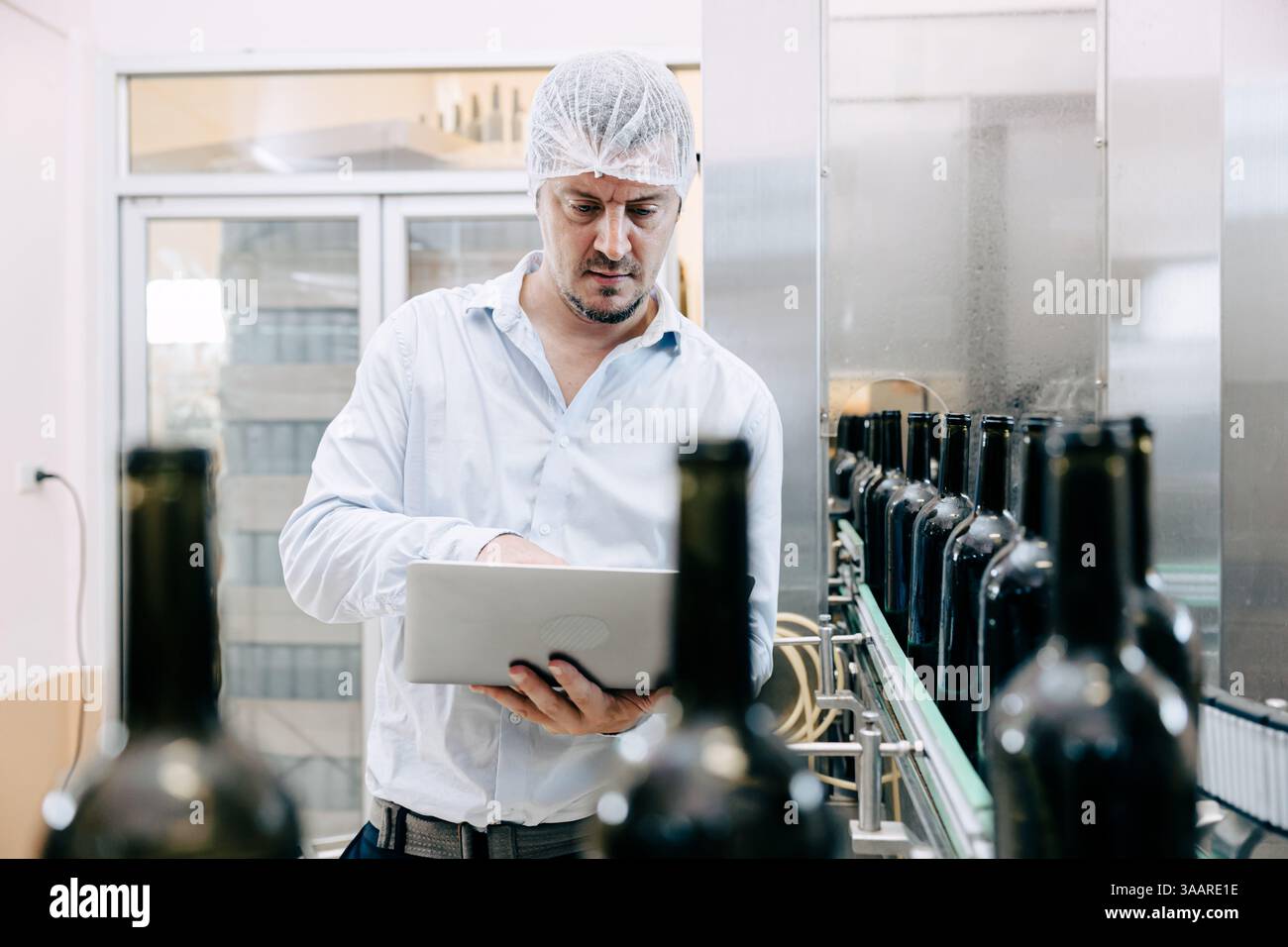 team di tecnici professionisti tecnici tecnici tecnici manutenzione di esperti. uomo che controlla la macchina nella linea di produzione della fabbrica di bevande per certificare lo standard di qualità Foto Stock