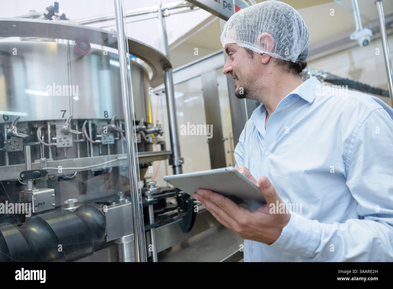 team di tecnici professionisti tecnici tecnici tecnici manutenzione di esperti. uomo che controlla la macchina nella linea di produzione della fabbrica di bevande per certificare lo standard di qualità Foto Stock