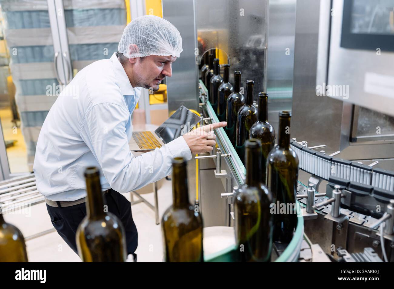 team di tecnici professionisti tecnici tecnici tecnici manutenzione di esperti. uomo che controlla la macchina nella linea di produzione della fabbrica di bevande per certificare lo standard di qualità Foto Stock