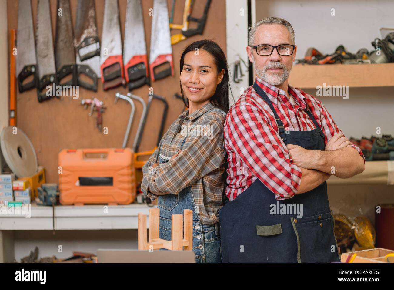 Ritratti squadra di falegnami professionisti in piedi sicuro sorriso felice lavoro progettare mobili in officina nella fabbrica di legno Foto Stock