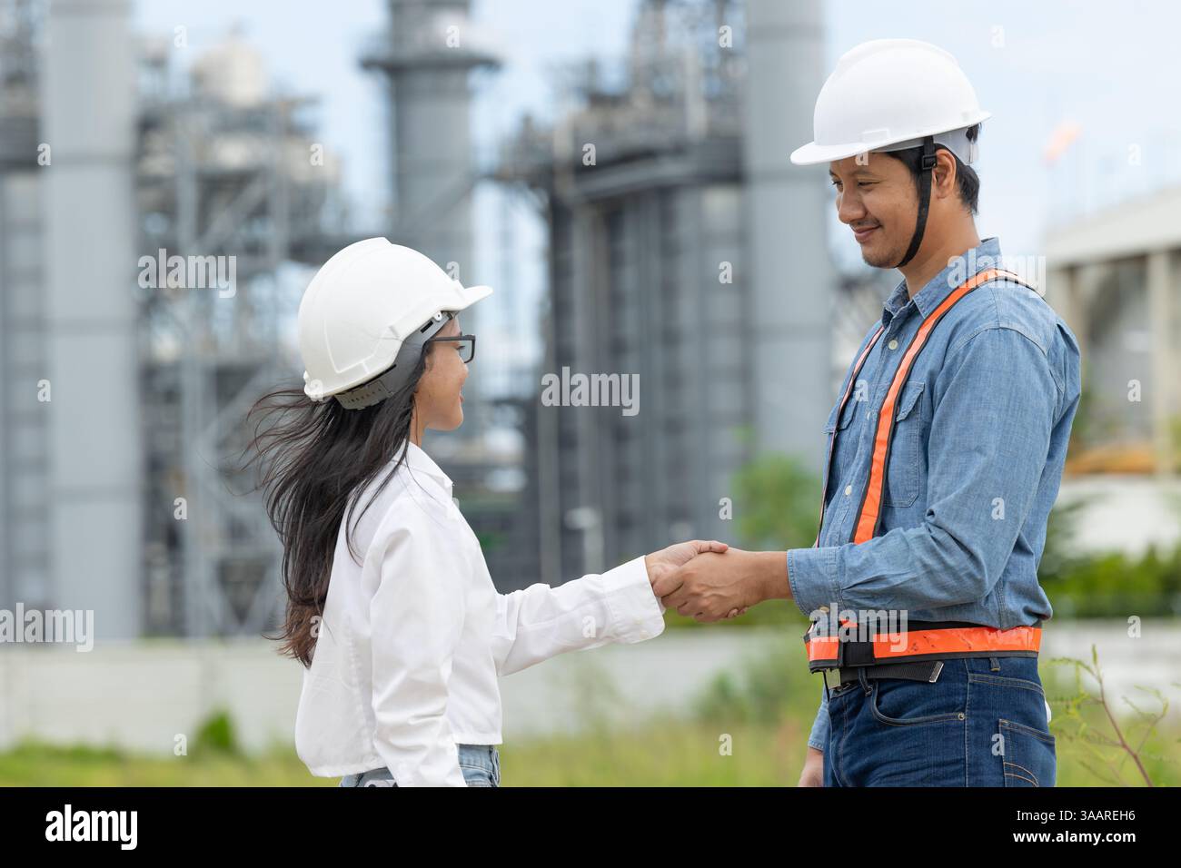 Team di ingegneri professionisti della raffineria petrolifera che si agitano a mano per gestire progetti di costruzione di petrolio e gas Foto Stock