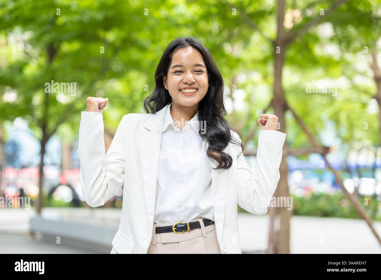 Felice successo donne d'affari, giovani donne d'affari in piedi allegri dalle buone notizie persone di successo nel verde parco all'aperto. Foto Stock