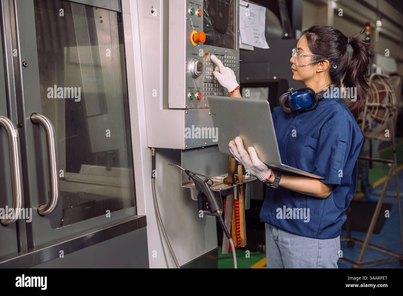 Lavoratrici di tornio che lavorano in officina con la fresatrice per metalli CNC digitale, lavoratrice esperta e abile del settore. Foto Stock