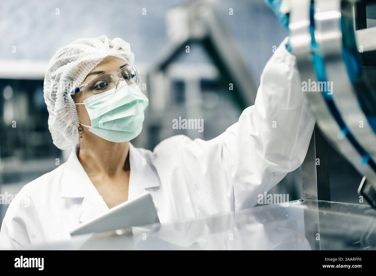 Gruppo ispettore industriale che lavora, il personale di controllo di qualità che controlla il funzionamento della macchina per la sicurezza e l'igiene nella fabbrica di bevande Foto Stock