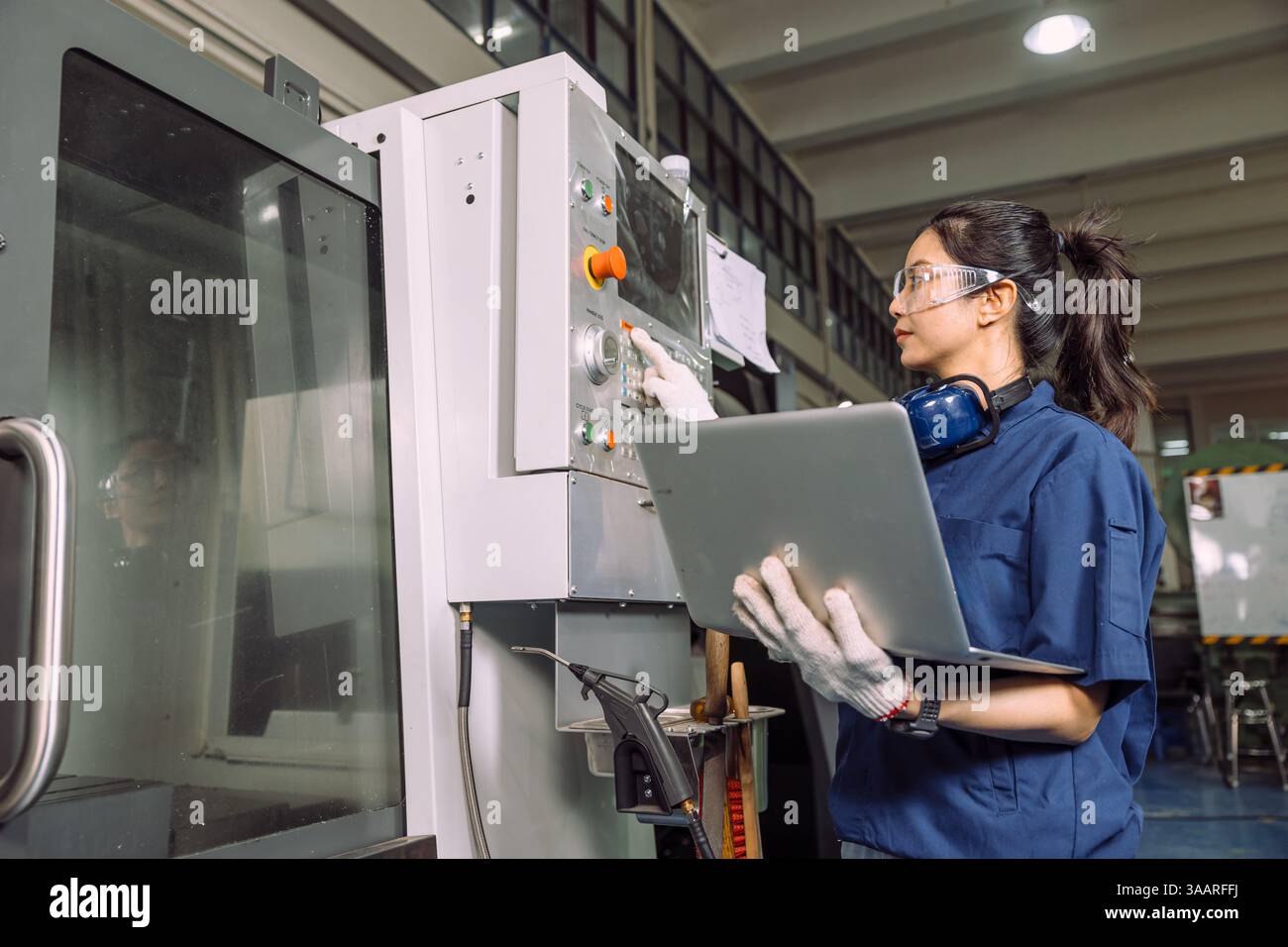 Lavoratrici di tornio che lavorano in officina con la fresatrice per metalli CNC digitale, lavoratrice esperta e abile del settore. Foto Stock