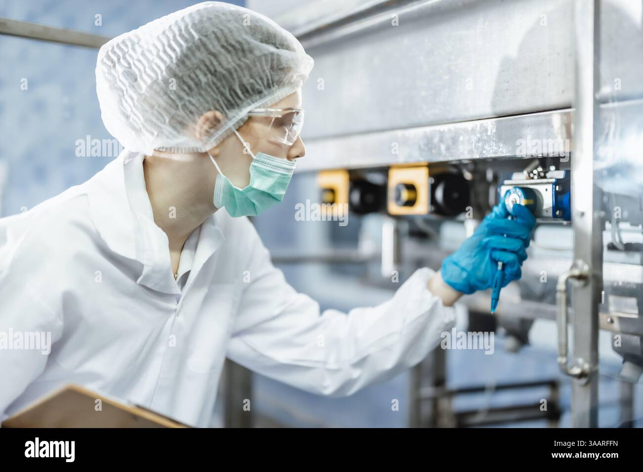 Gruppo ispettore industriale che lavora, il personale di controllo di qualità che controlla il funzionamento della macchina per la sicurezza e l'igiene nella fabbrica di bevande Foto Stock
