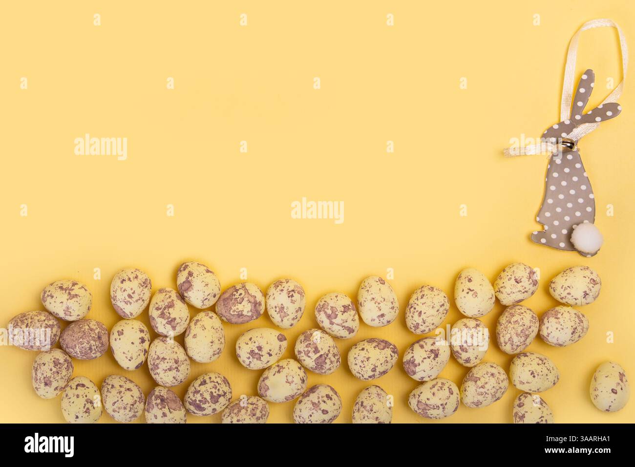 Uova di Pasqua e carta carina coniglietto pasquale su sfondo giallo con spazio negativo Foto Stock