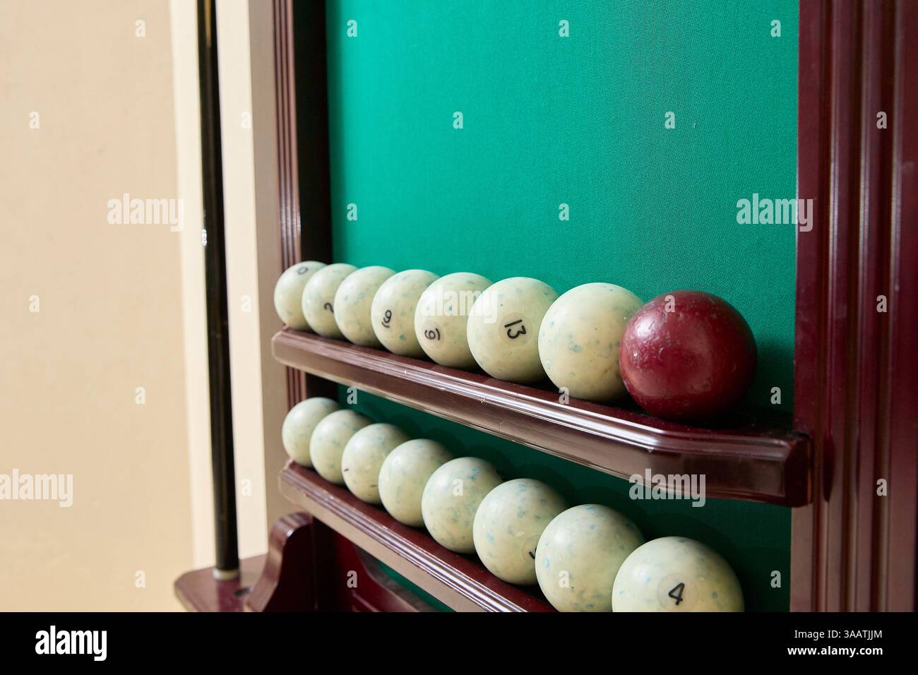 Primo piano di un rack da biliardo con una fila di palline bianche numerate e una palla rossa. La disposizione mostra la classica disposizione dei tavoli da biliardo, emph Foto Stock