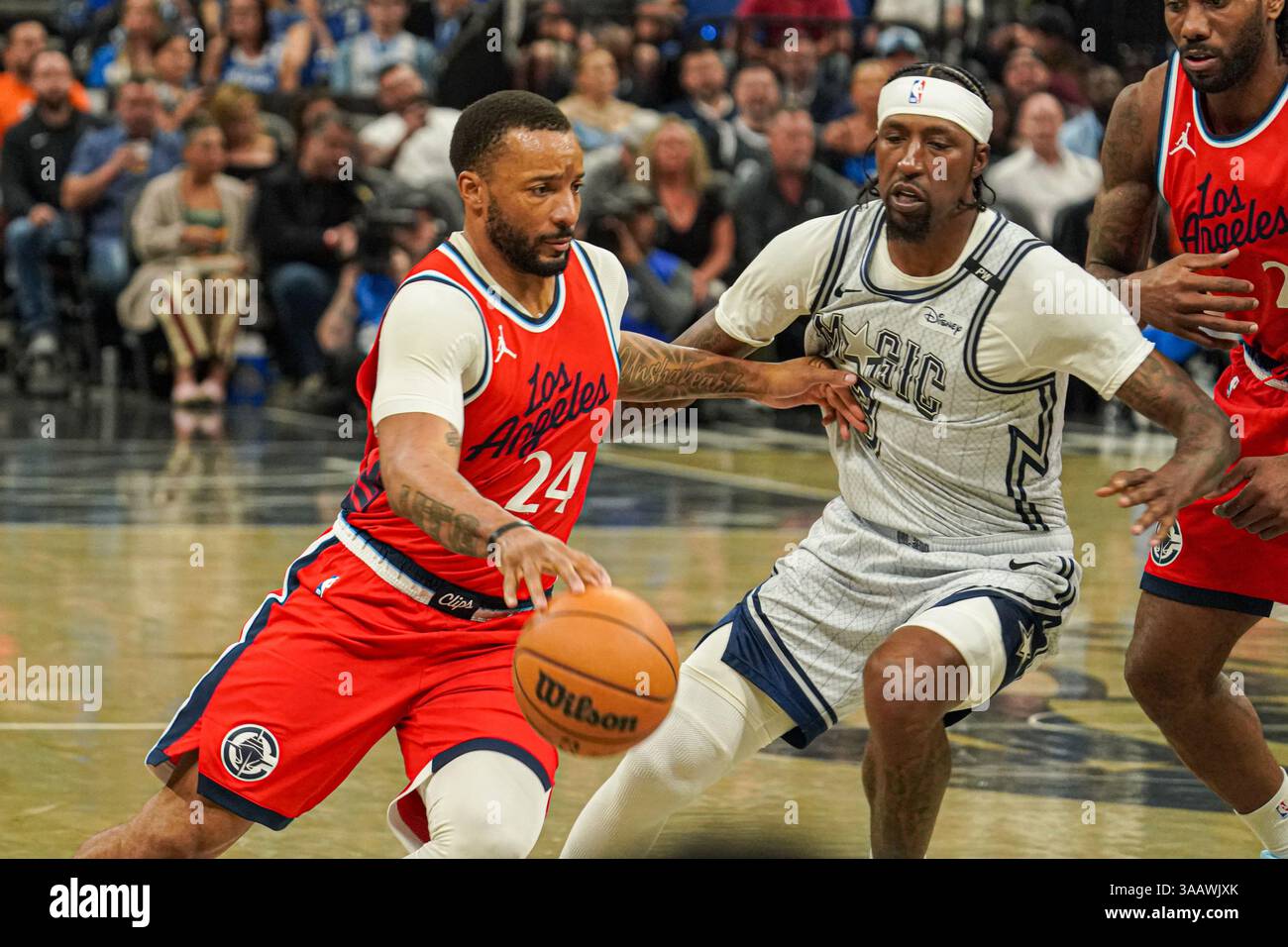 Orlando, Florida, Stati Uniti, 31 marzo 2025, l'attaccante dei Los Angeles Clippers Norman Powell #24 passa subito Kentavious Caldwell-Pope #3 al Kia Center. (Foto: Marty Jean-Louis/Alamy Live News Foto Stock