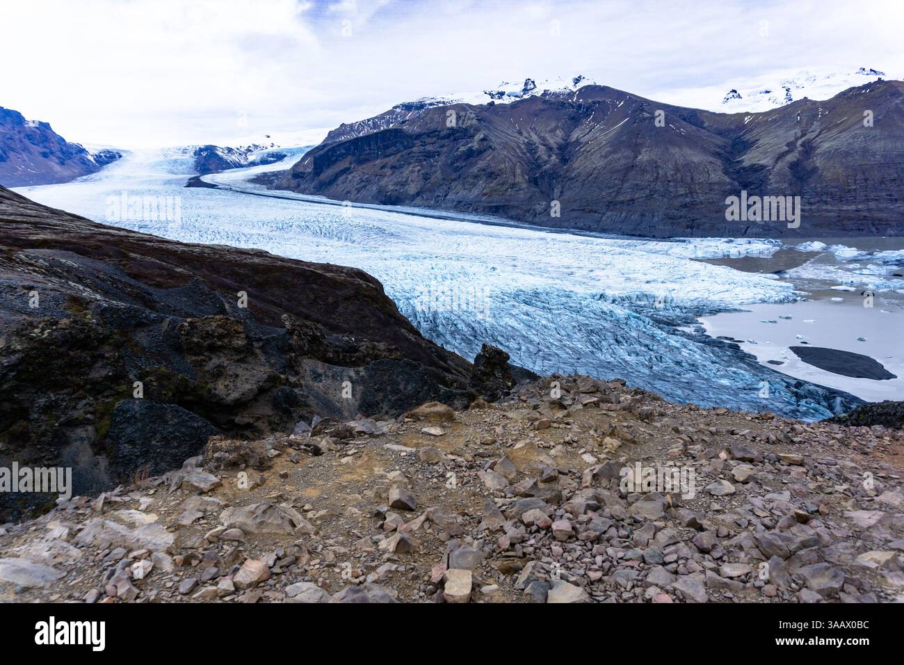 Lingua del ghiacciaio Skaftafellsjokull nel Parco Nazionale di Vatnajokull, Islanda, con formazioni di ghiaccio e paesaggio di montagna Rugged sullo sfondo Foto Stock
