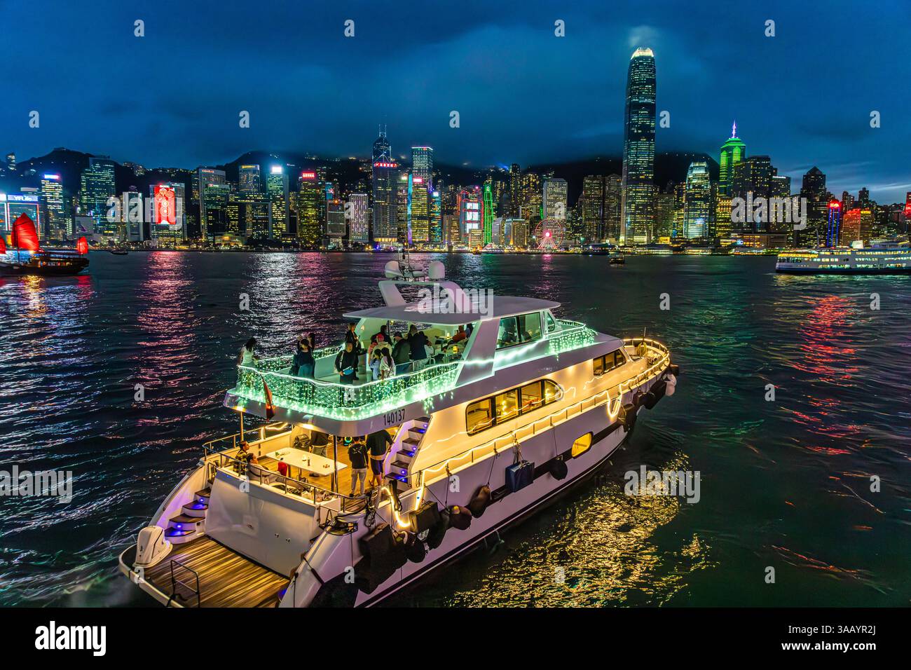 Una barca turistica per una crociera serale al tramonto nel Victoria Harbour, Hong Kong, Kowloon, Cina Foto Stock
