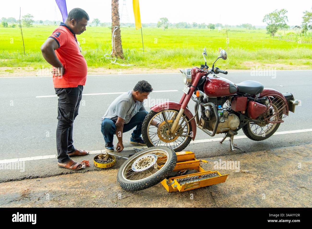 Sri Lanka, RAID motociclistico Vintage Royal Enfield, da Trincomalee a Wasgamuwa Road, guasto, sostituzione delle ruote anteriori a causa di un guasto dei cuscinetti Foto Stock