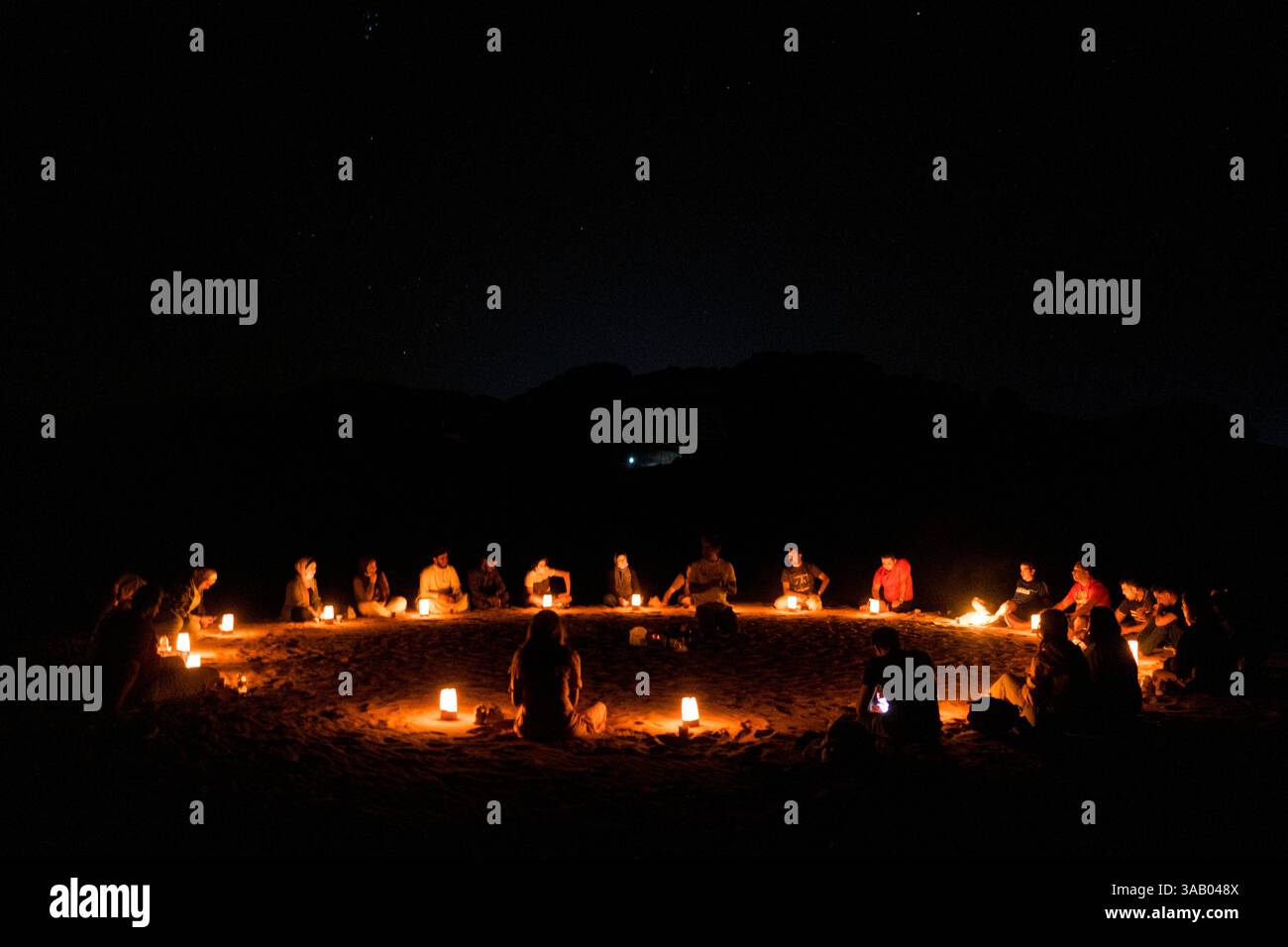 WADI RUM, GIORDANIA - 10 SETTEMBRE 2021: Turisti intorno a un falò, bevendo tè e cantando canzoni nel deserto di Wadi Rum. CREDITO: Daniel Rodrigues Foto Stock