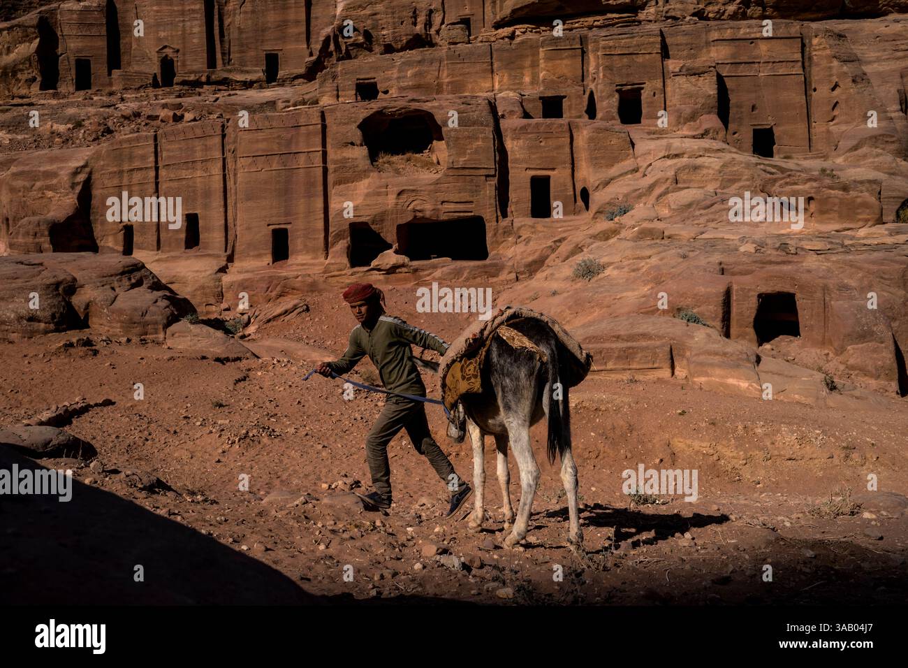 WADI MUSA, GIORDANIA - 10 SETTEMBRE 2021: Beduino con un asino presso la via delle facciate di Petra. CREDITO: Daniel Rodrigues Foto Stock