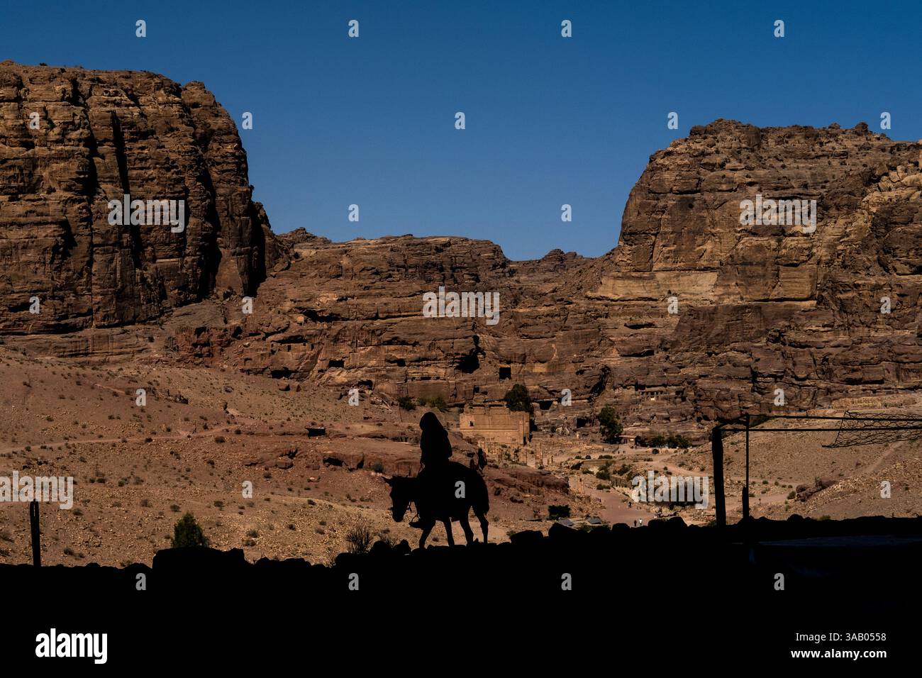 WADI MUSA, GIORDANIA - 10 SETTEMBRE 2021: Beduino con un asino di fronte alla strada delle facciate di Petra. CREDITO: Daniel Rodrigues Foto Stock