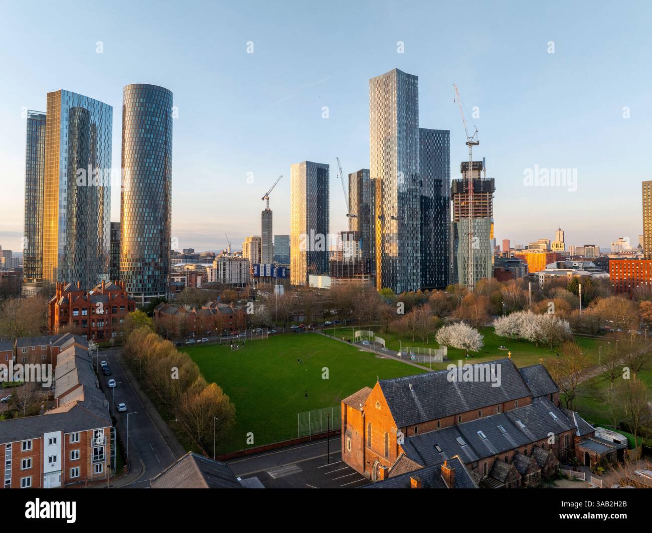 Immagine aerea di Hulme Park a Manchester con lo skyline della città al tramonto Foto Stock