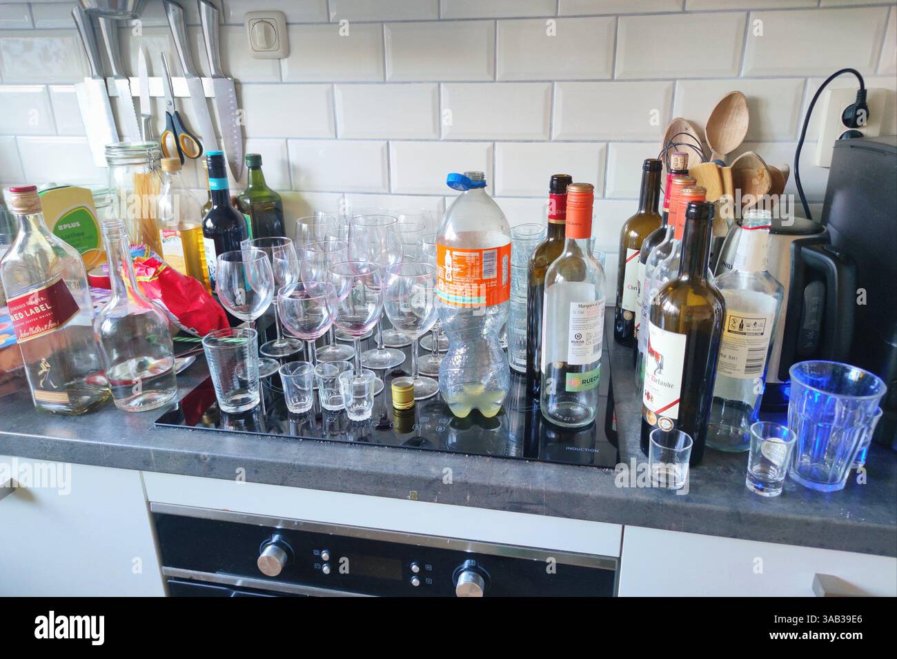 Svuotare bottiglie e bicchieri su un piano di lavoro dopo una festa in casa Foto Stock