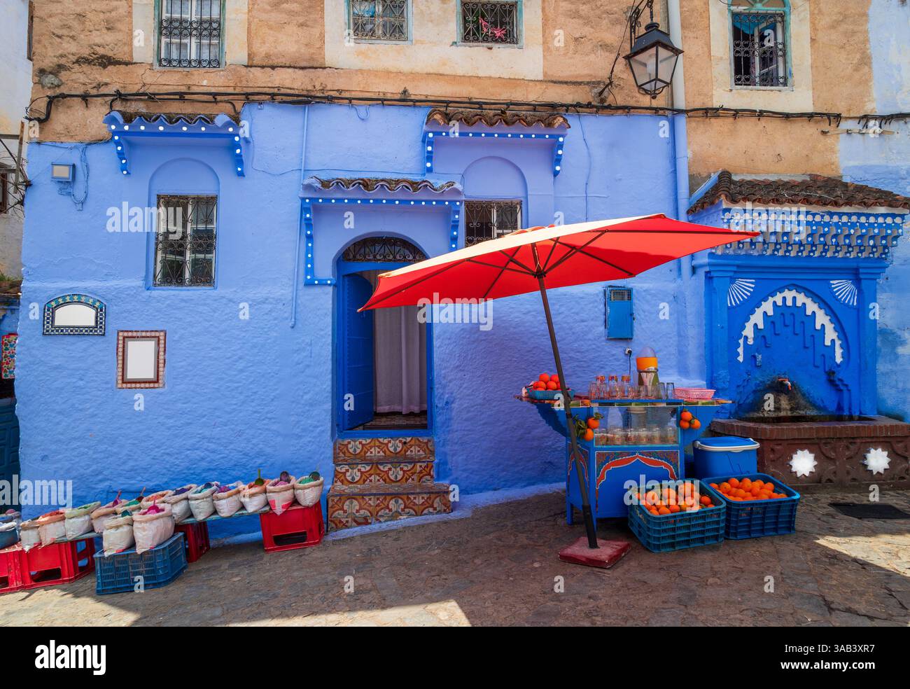 Casa tradizionale blu a Plaza Kenitra, Marocco, una vivace piazza con spezie locali e un negozio di succo d'arancia fresco Foto Stock
