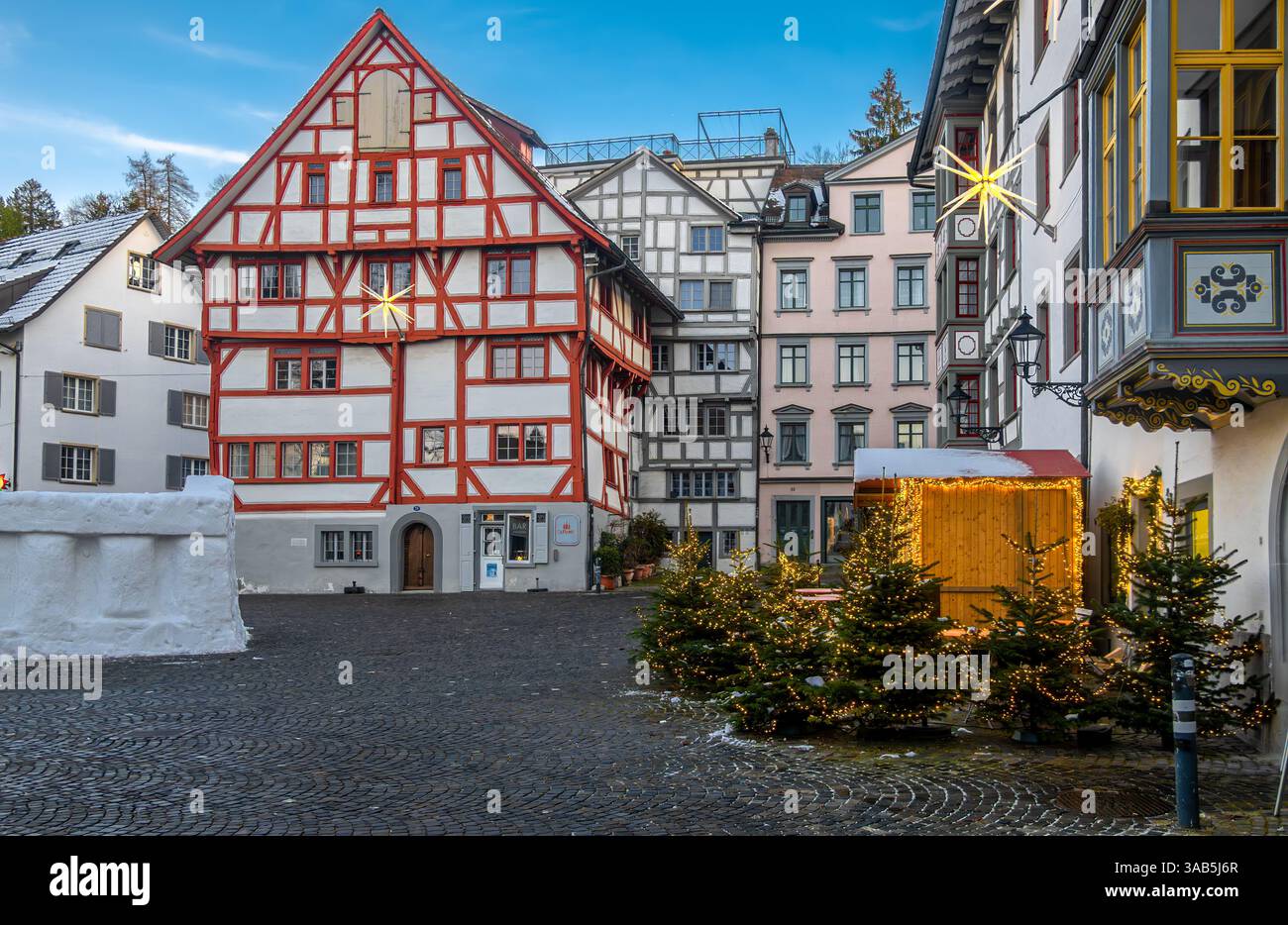 Sankt Gallen, Svizzera - 1° gennaio 2025: Pittoresca piazza cittadina con tradizionali edifici in legno, decorati con luci natalizie e sma Foto Stock
