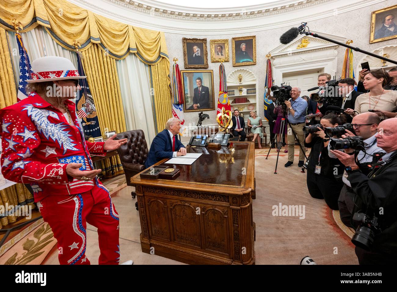 Washington, Stati Uniti. 31 marzo 2025. Il musicista Kid Rock, a sinistra, parla ai media come U. Il presidente Donald Trump, guarda prima della firma di un ordine esecutivo che vieta lo scalping dei biglietti sfruttativi presso l'Ufficio ovale della Casa Bianca, 31 marzo 2025 a Washington, DC Credit: Molly Riley/White House Photo/Alamy Live News Foto Stock