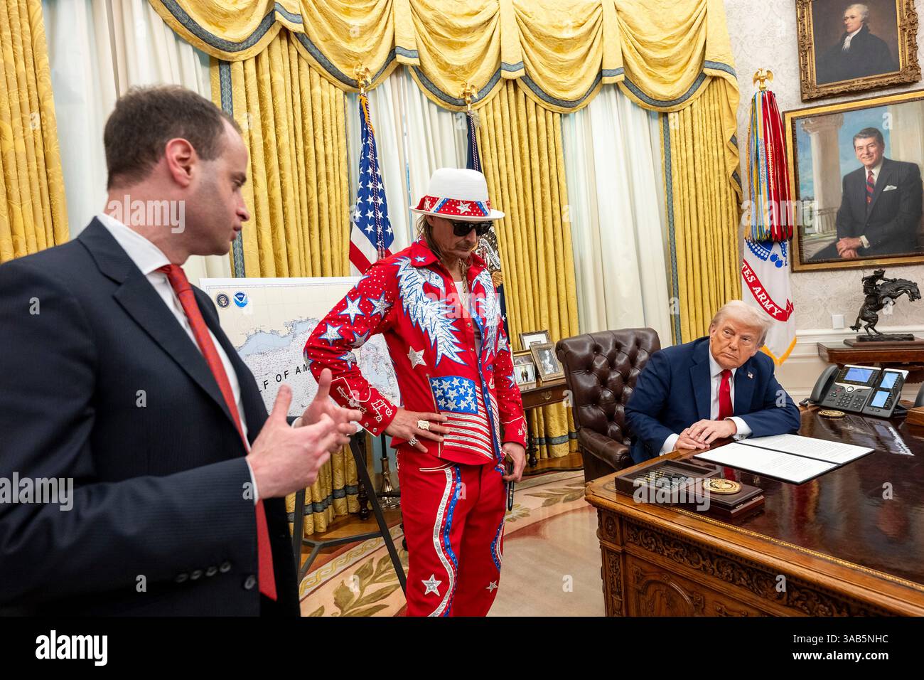 Washington, Stati Uniti. 31 marzo 2025. Il segretario dello staff della Casa Bianca Will Scharf, a sinistra, commenta come musicista Kid Rock, Center e U. Presidente Donald Trump, guarda prima della firma di un ordine esecutivo che vieta lo scalping dei biglietti sfruttativi presso l'Ufficio ovale della Casa Bianca, 31 marzo 2025 a Washington, DC Credit: Molly Riley/White House Photo/Alamy Live News Foto Stock