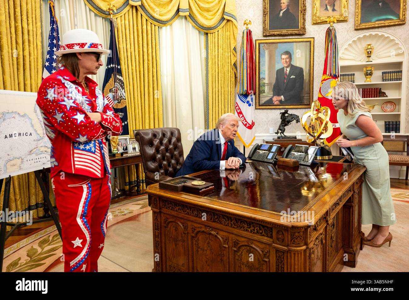 Washington, Stati Uniti. 31 marzo 2025. Il segretario stampa della Casa Bianca Karoline Leavitt, a destra, ascolta U. Il presidente Donald Trump, mentre il musicista Kid Rock ha lasciato, guarda prima della firma di un ordine esecutivo che vieta lo scalping dei biglietti sfruttativi presso l'Ufficio ovale della Casa Bianca, 31 marzo 2025 a Washington, DC Credit: Molly Riley/White House Photo/Alamy Live News Foto Stock