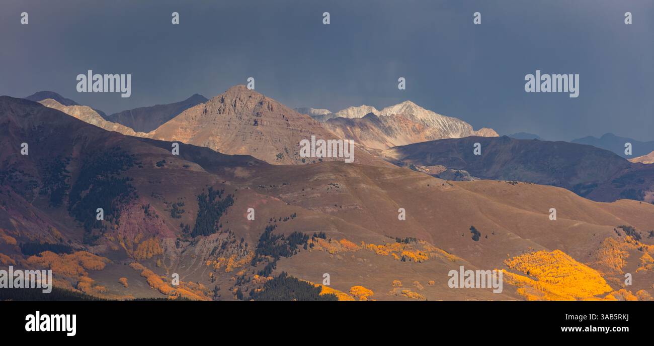 Riflettori puntati sul monte Teocalli (13,213'), Star Peak di colore chiaro (13,527') e i vibranti alberi di pioppo mentre il resto della catena degli alci giace in ombra. Foto Stock