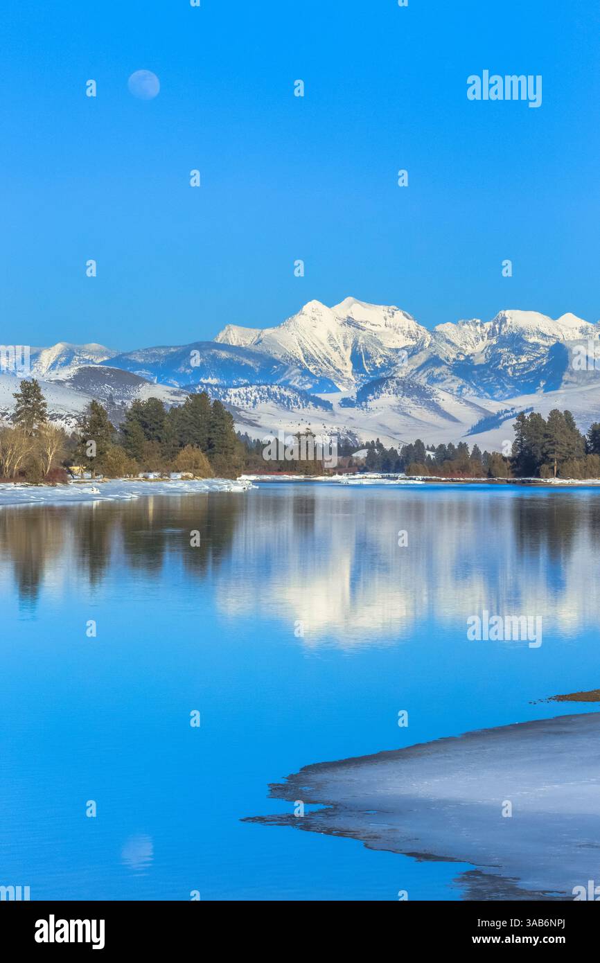 Luna crescente oltre il fiume flathead e missione le montagne in inverno vicino a Dixon, montana Foto Stock