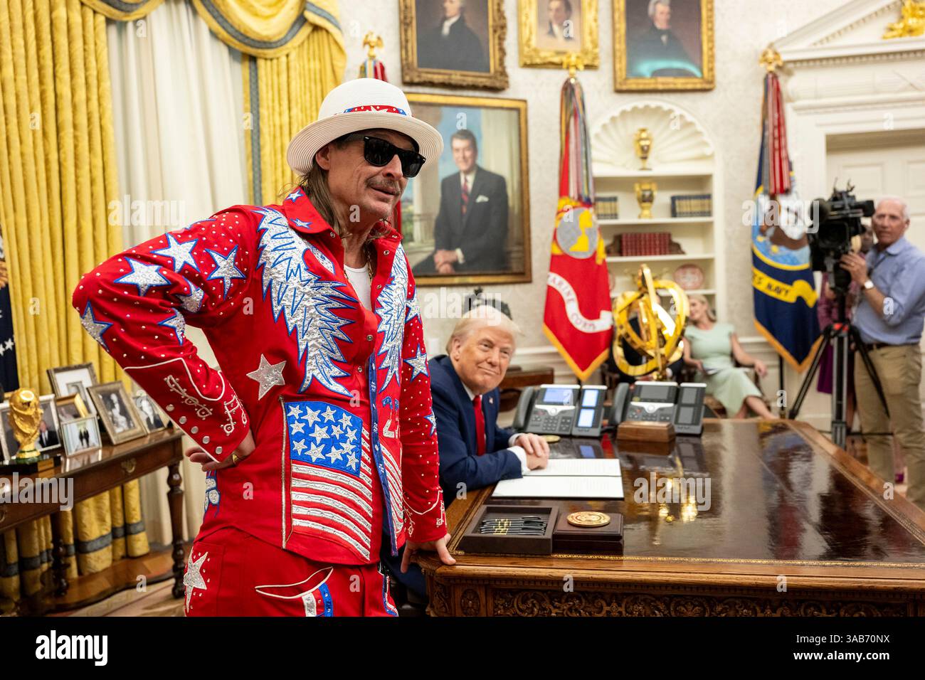 Washington, Stati Uniti. 31 marzo 2025. U. Il presidente Donald Trump firma un ordine esecutivo che vieta lo scalpore dei biglietti sfruttativi mentre il musicista Kid Rock, a sinistra, guarda all'ufficio ovale della Casa Bianca, 31 marzo 2025 a Washington, DC Credit: Molly Riley/White House Photo/Alamy Live News Foto Stock