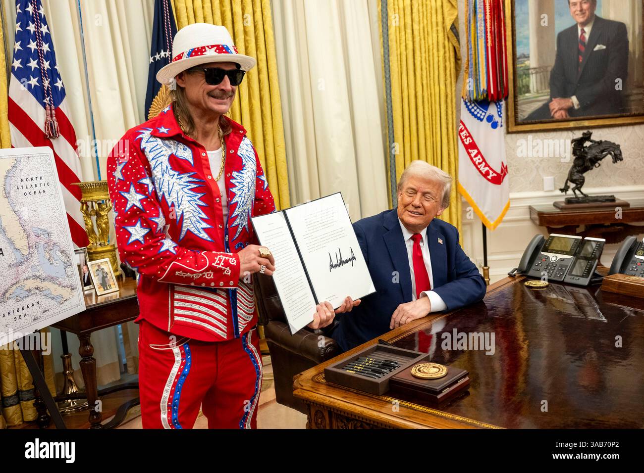Washington, Stati Uniti. 31 marzo 2025. Il musicista Kid Rock, a sinistra, detiene l'ordine esecutivo firmato che vieta lo sfruttamento dei biglietti scalping come U. Il presidente Donald Trump, guarda l'ufficio ovale della Casa Bianca, 31 marzo 2025 a Washington, DC Credit: Molly Riley/White House Photo/Alamy Live News Foto Stock