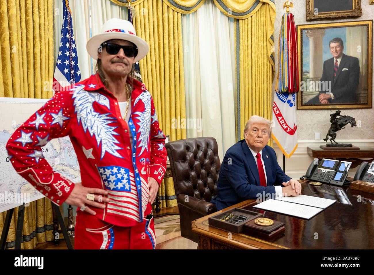 Washington, Stati Uniti. 31 marzo 2025. U. Il presidente Donald Trump firma un ordine esecutivo che vieta lo scalpore dei biglietti sfruttativi mentre il musicista Kid Rock, a sinistra, guarda all'ufficio ovale della Casa Bianca, 31 marzo 2025 a Washington, DC Credit: Molly Riley/White House Photo/Alamy Live News Foto Stock