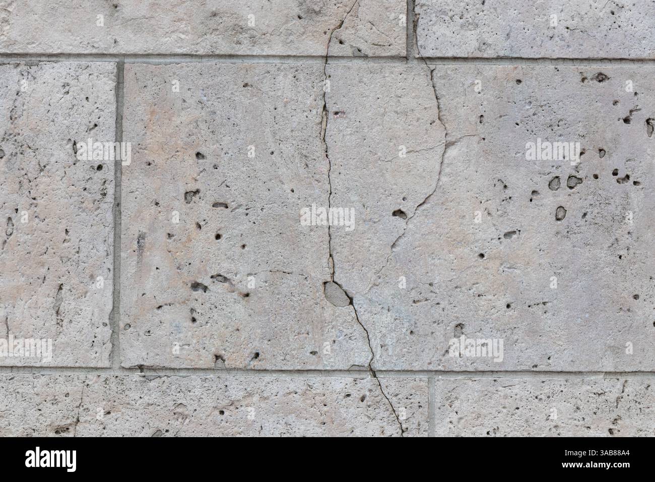 Pareti piastrellate in pietra grigia, mattoni calcarei naturali con crepe, sfondo per sfondi o design di striscioni Web. Foto Stock