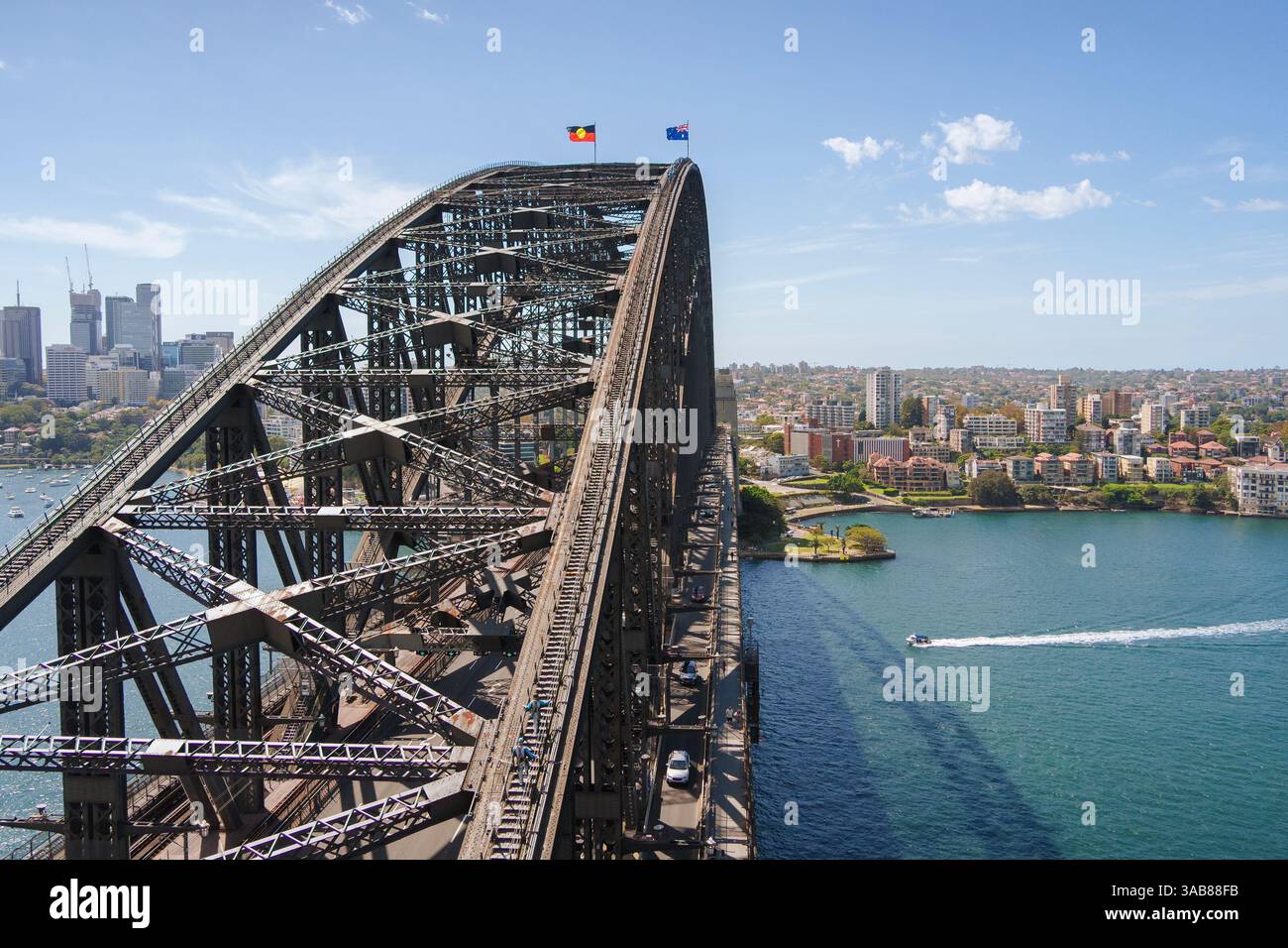 Una barca naviga verso l'iconico arco del Sydney Harbour Bridge nel Sydney Harbour Australia Foto Stock