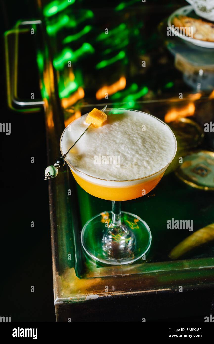 Un cocktail di pesca splendidamente realizzato visto dall'alto, che mostra la sua consistenza frizzante e la delicata decorazione. Foto Stock