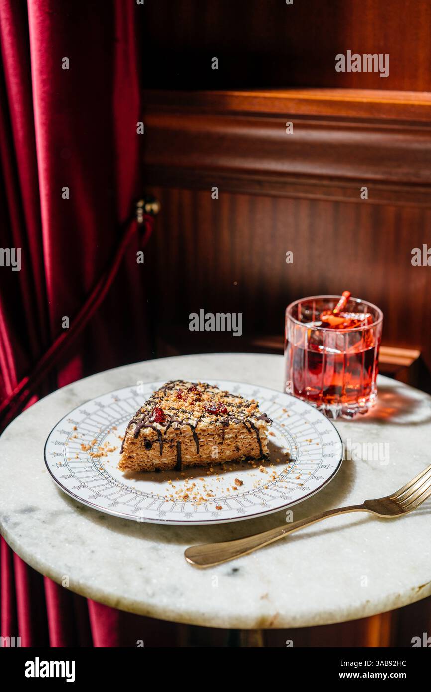 Una deliziosa torta a base di waffle ricoperta di latte condensato cremoso al tartufo, ricoperta da gocciolatoio di cioccolato, noci e ciliegie secche. Perfetto per un lusso Foto Stock