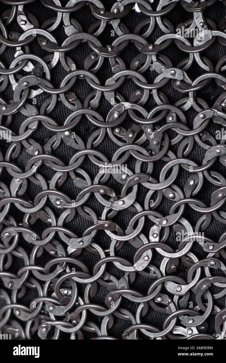 Primo piano dettagliato degli squilli Medieval Chainmail interbloccati. Trama complessa di maglie metalliche che formano un tessuto difensivo resistente e flessibile. Foto Stock
