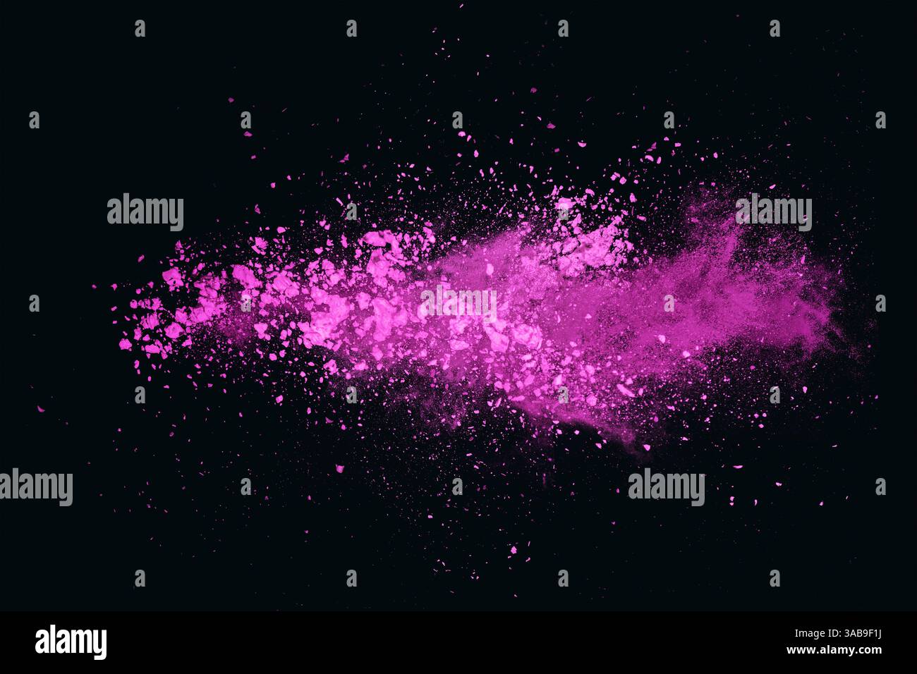 Una vivace nuvola di polvere di colore rosa galleggia su uno sfondo nero, creando un contrasto accattivante con intense sfumature di fucsia e m. Foto Stock