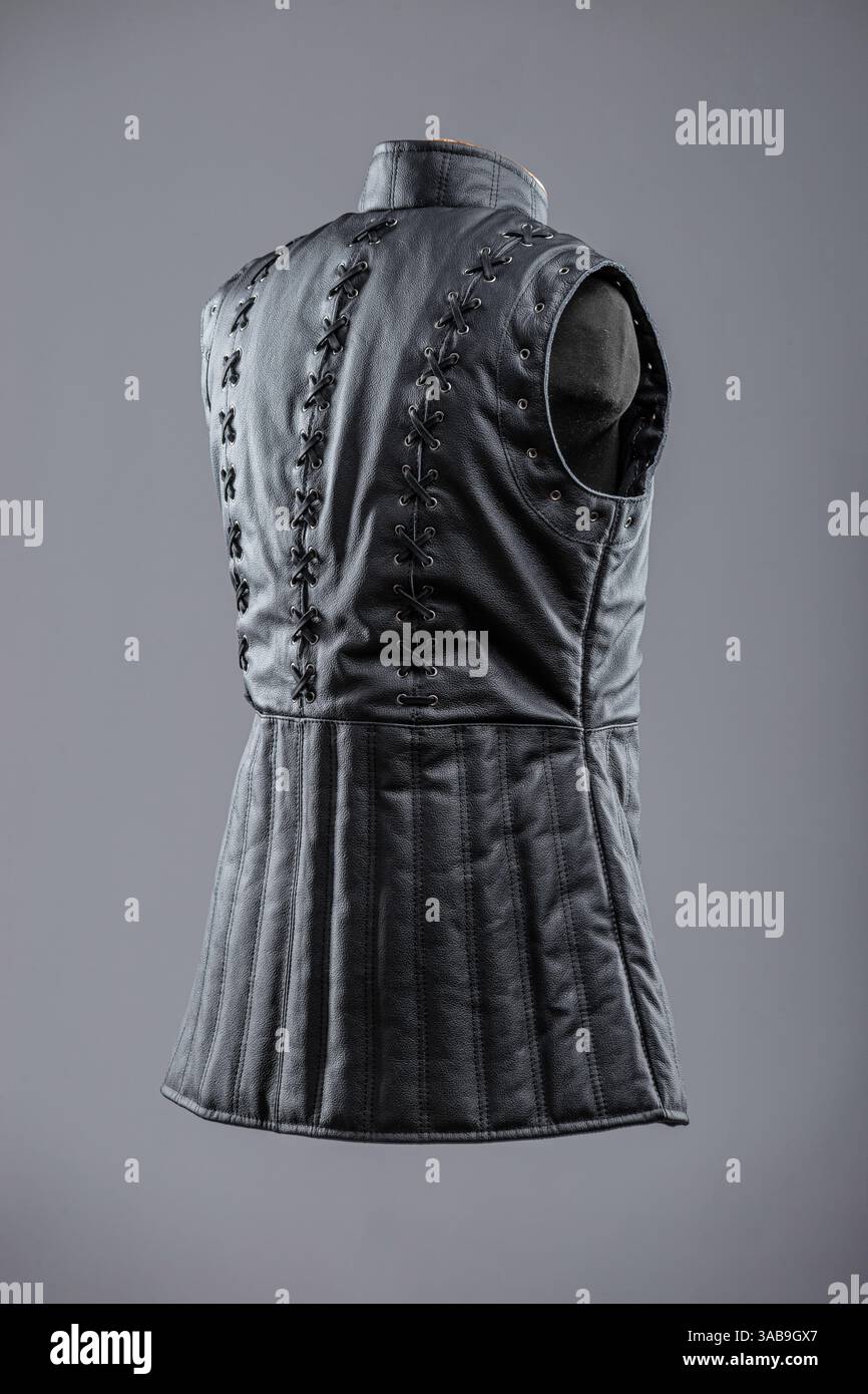 Giacca senza maniche in pelle nera con allacciatura e fibbie. Questa immagine mostra una giacca o un gilet senza maniche in pelle nera con collo alto. È dotato di de Foto Stock