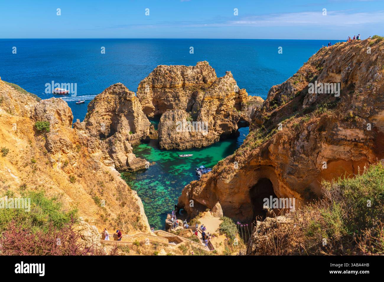 I turisti e i visitatori scendono i gradini per raggiungere le barche Ponta da Piedade, Lagos, Algarve, Portogallo Foto Stock
