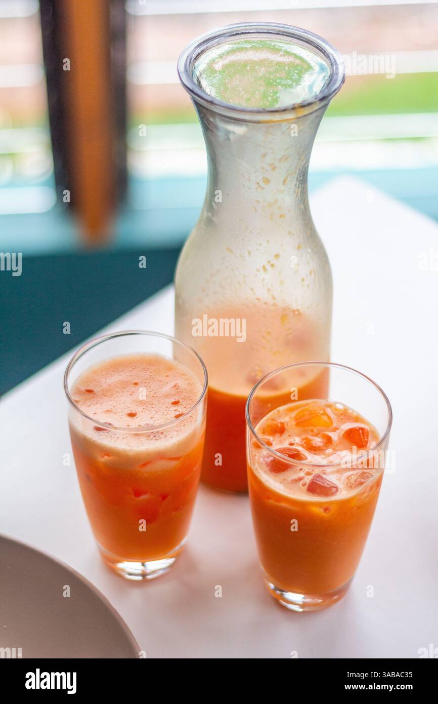 Succo di papaya di colore rosso arancio servito in bicchieri chiari in un ristorante locale a Mindanao nelle Filippine pronto per essere gustato freddo Foto Stock