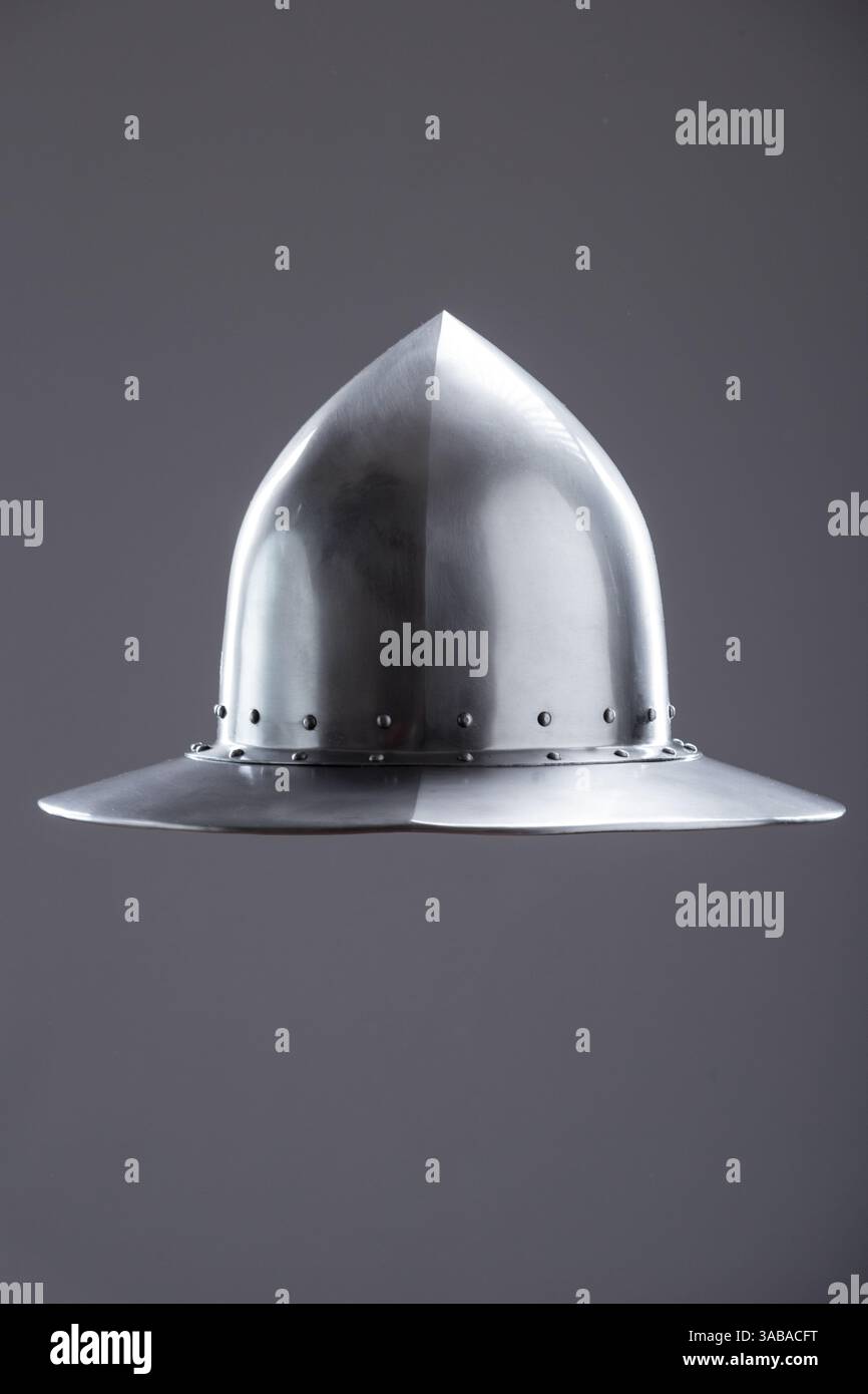 Cappello da bollitore medievale in acciaio lucido. Vista frontale di un casco medievale in acciaio lucido con cupola a punta, ampio bordo e rivetti su un Foto Stock