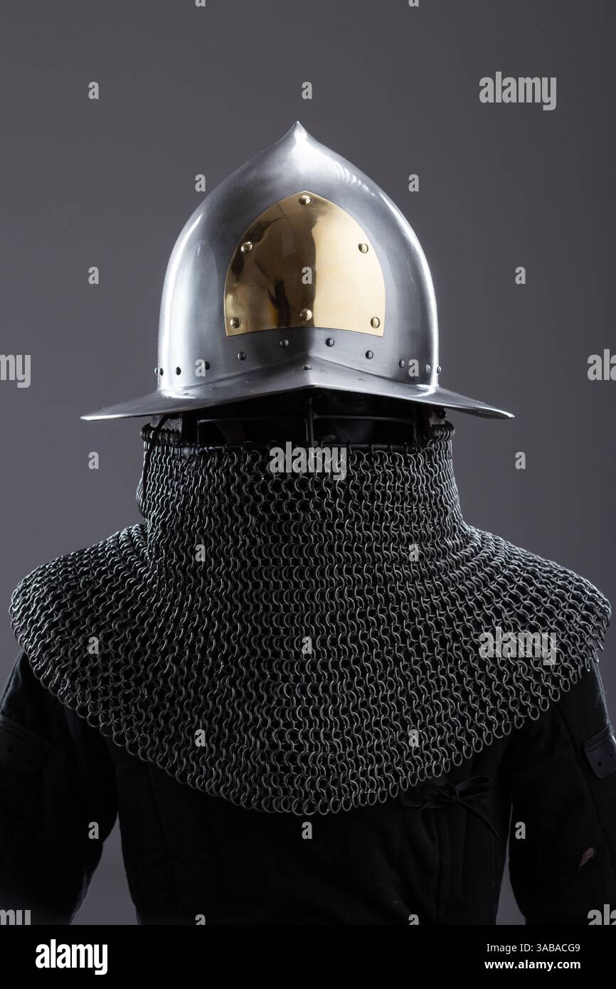 Elegante casco medievale con accento dorato e Chainmail. Sofisticata protezione per la testa con finitura lucida, dettagli dorati e catena attaccata Foto Stock