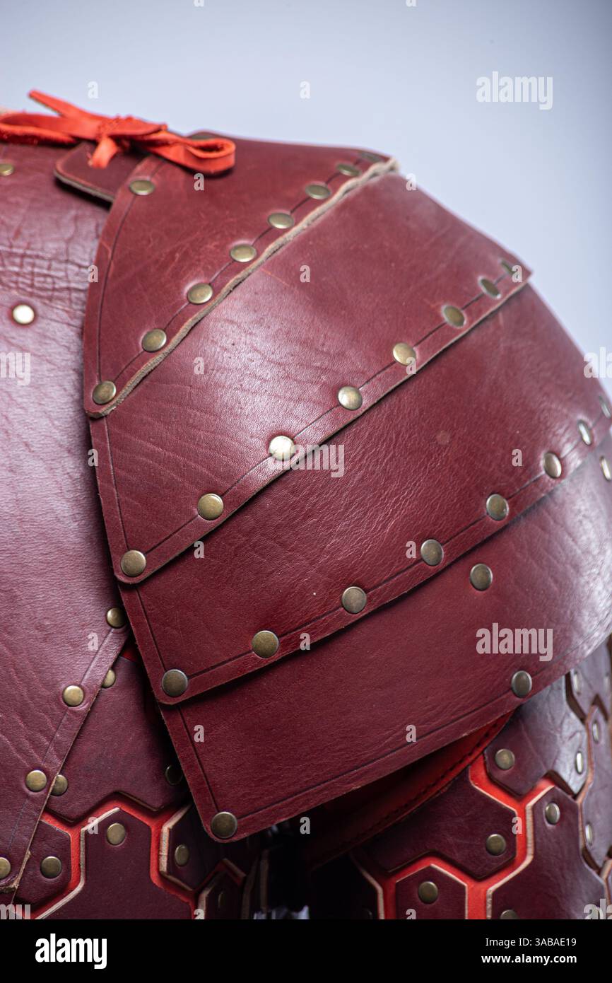 Primo piano dell'armatura a spalla Fantasy in pelle marrone. Vista dettagliata dello spallamento con rivetti e giunzione rossa. Foto Stock