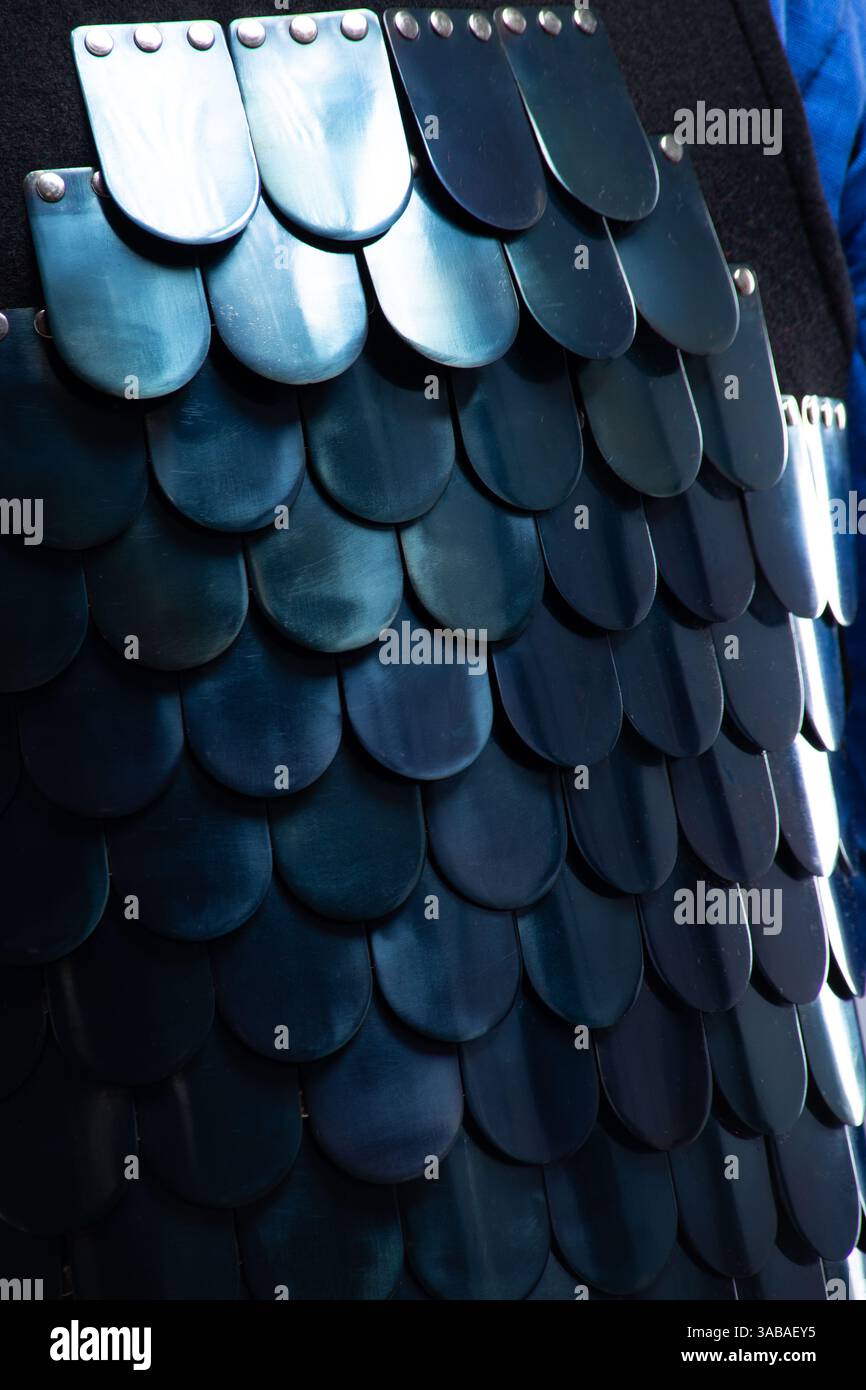Primo piano di scale dell'armatura lamellare bizantina. Vista dettagliata delle piastre metalliche sovrapposte su un'armatura in scala medievale. Foto Stock
