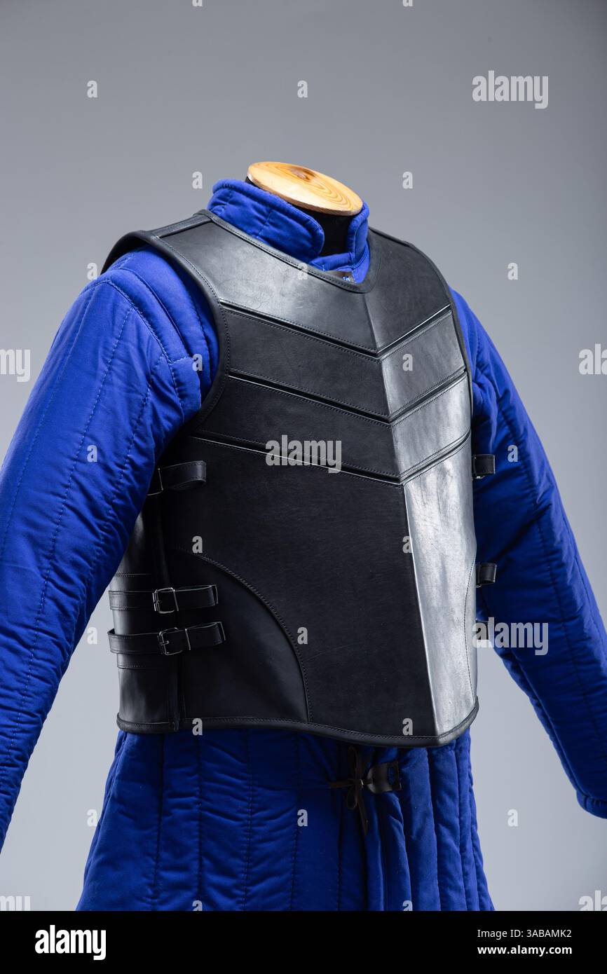 Corazza in pelle nera con cinghie regolabili. Questa immagine presenta un'armatura in pelle nera con un design segmentato sul petto e una S regolabile Foto Stock