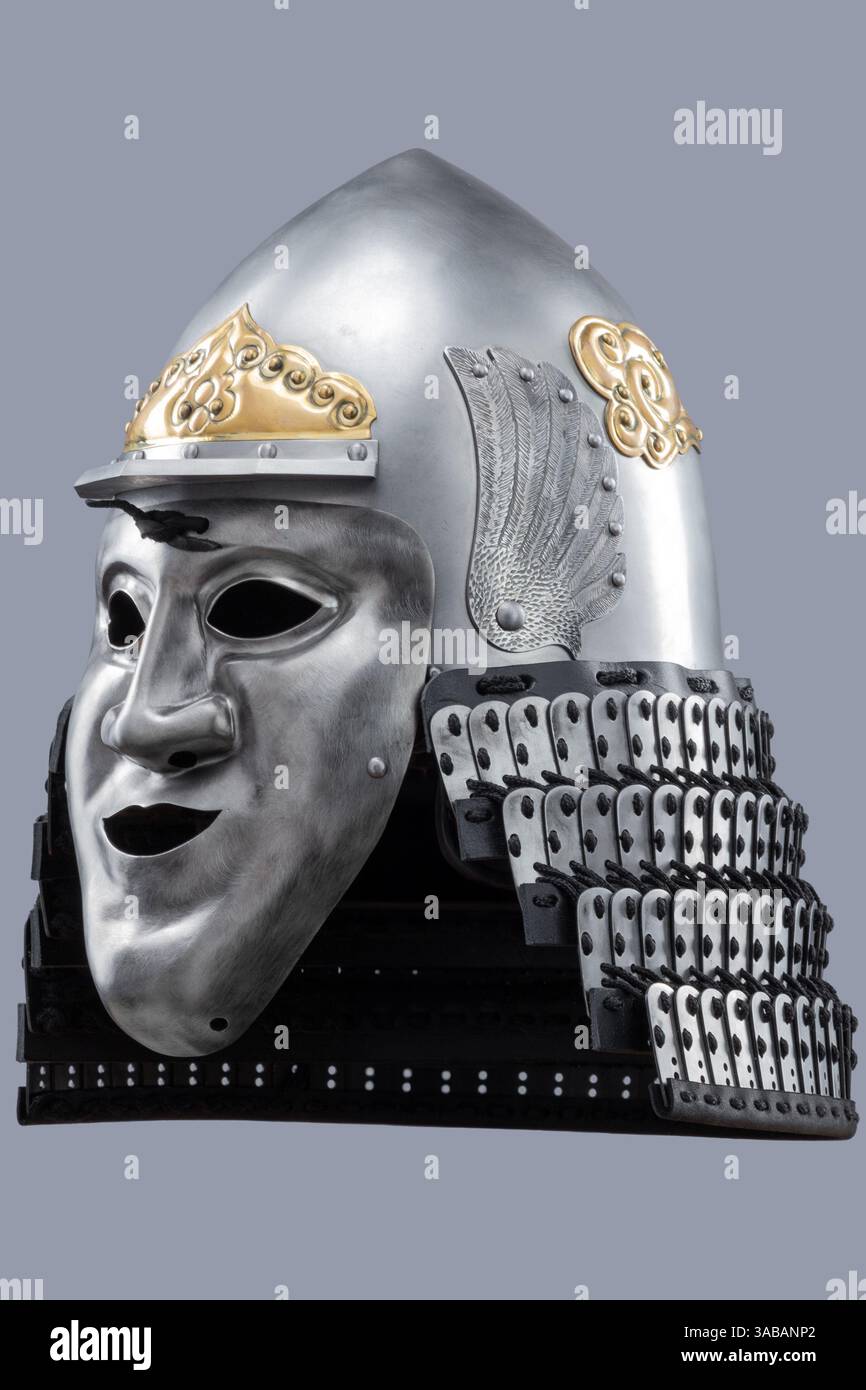 Casco Samurai in argento con dettagli dorati e maschera Fierce. Questa immagine mostra un casco samurai argentato con intricate decorazioni dorate sul cr Foto Stock