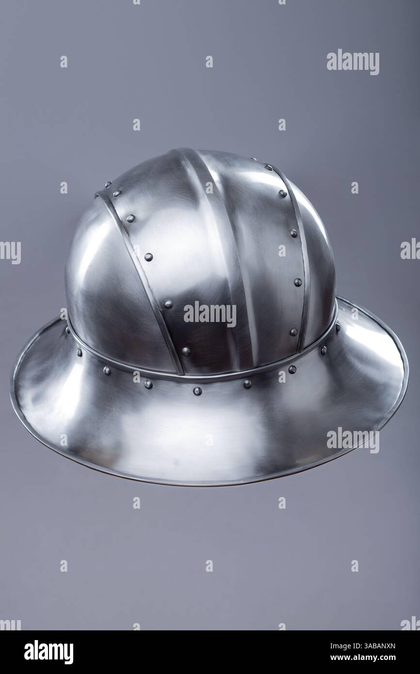 Elmetto argento con bordo largo e rivetti. Questa immagine mostra un casco in argento lucido con un bordo largo e inclinato verso il basso e diversi piccoli rivetti lungo Foto Stock